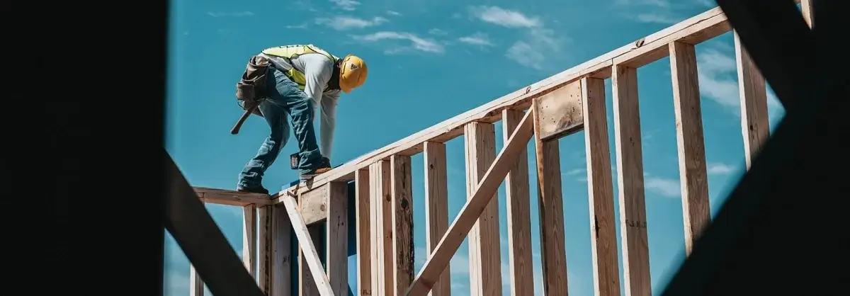 Construction worker securing roof frame